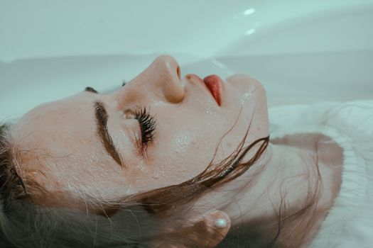 闭着眼睛躺在浴缸里的年轻女子，体现了和平与安宁