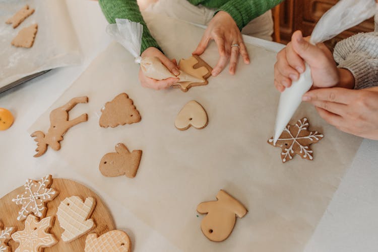 Two Girls Decorating Christmas Cookies With Icing