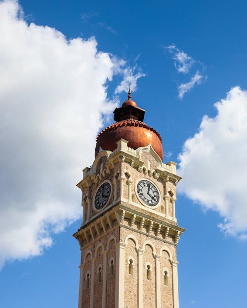 Brown and White Clock Tower Under the Blue Sky