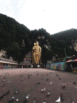 在吉隆坡巴图洞穴，穆鲁根勋爵的金色雕像周围都是鸽子