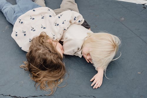 Gadis Berbaju Bintang Putih Dan Kaos Hitam Berbaring Di Lantai Beton Abu Abu