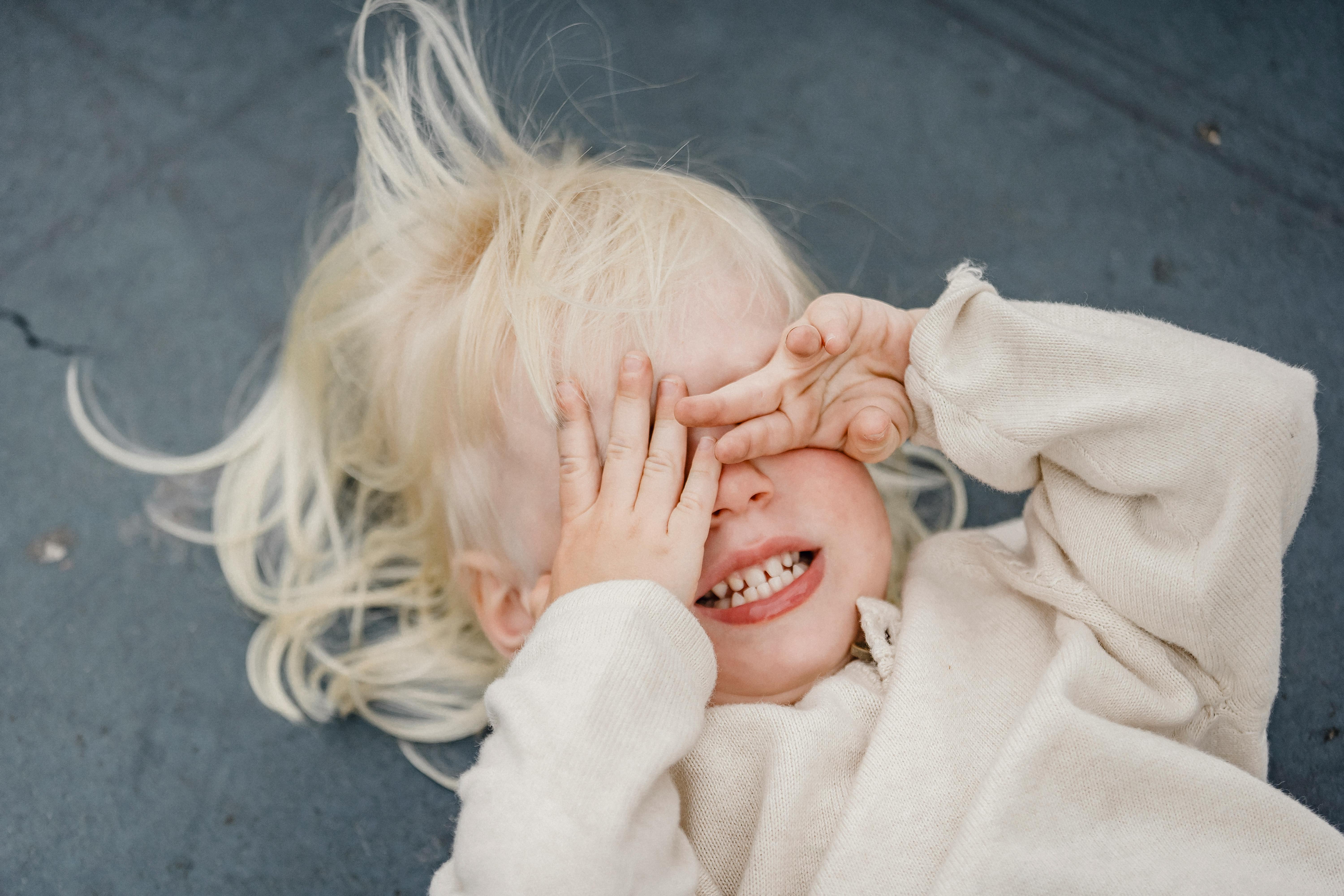 playful little girl covering her eyes