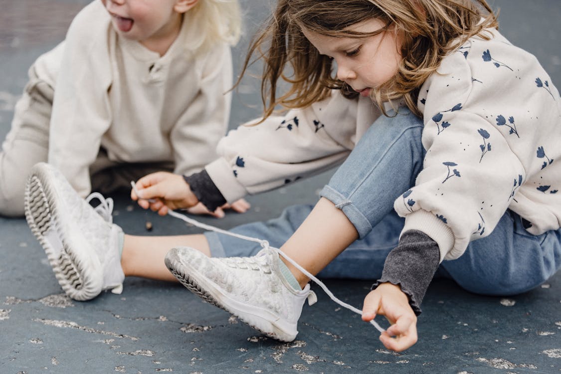 Free Crop girl tying shoelaces on playground Stock Photo