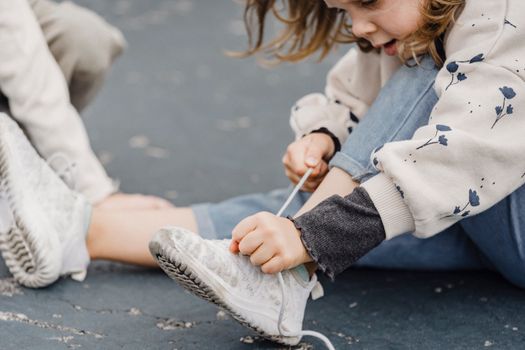 Crop girl tying laces on sneakers
