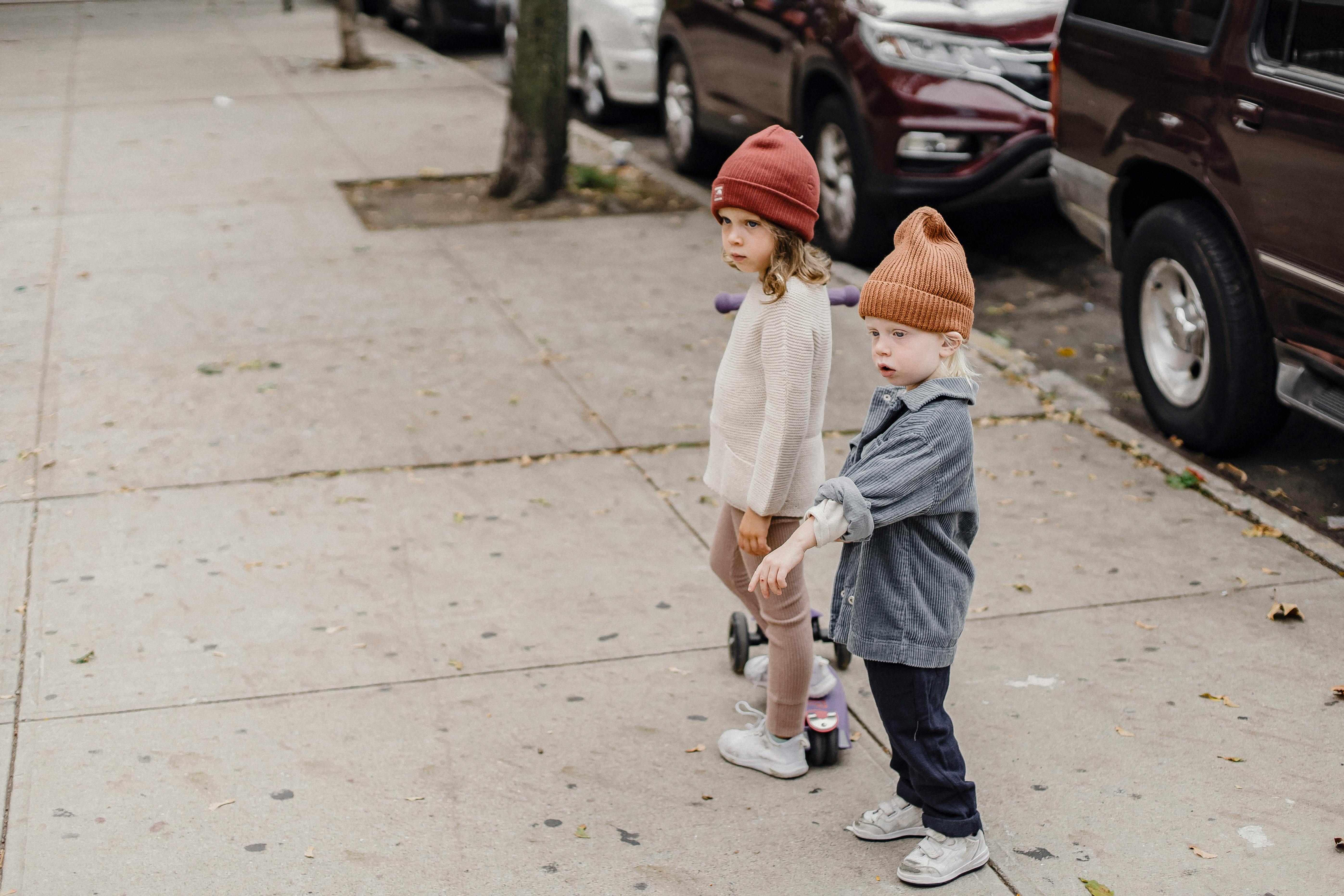 stylish siblings standing on sidewalk