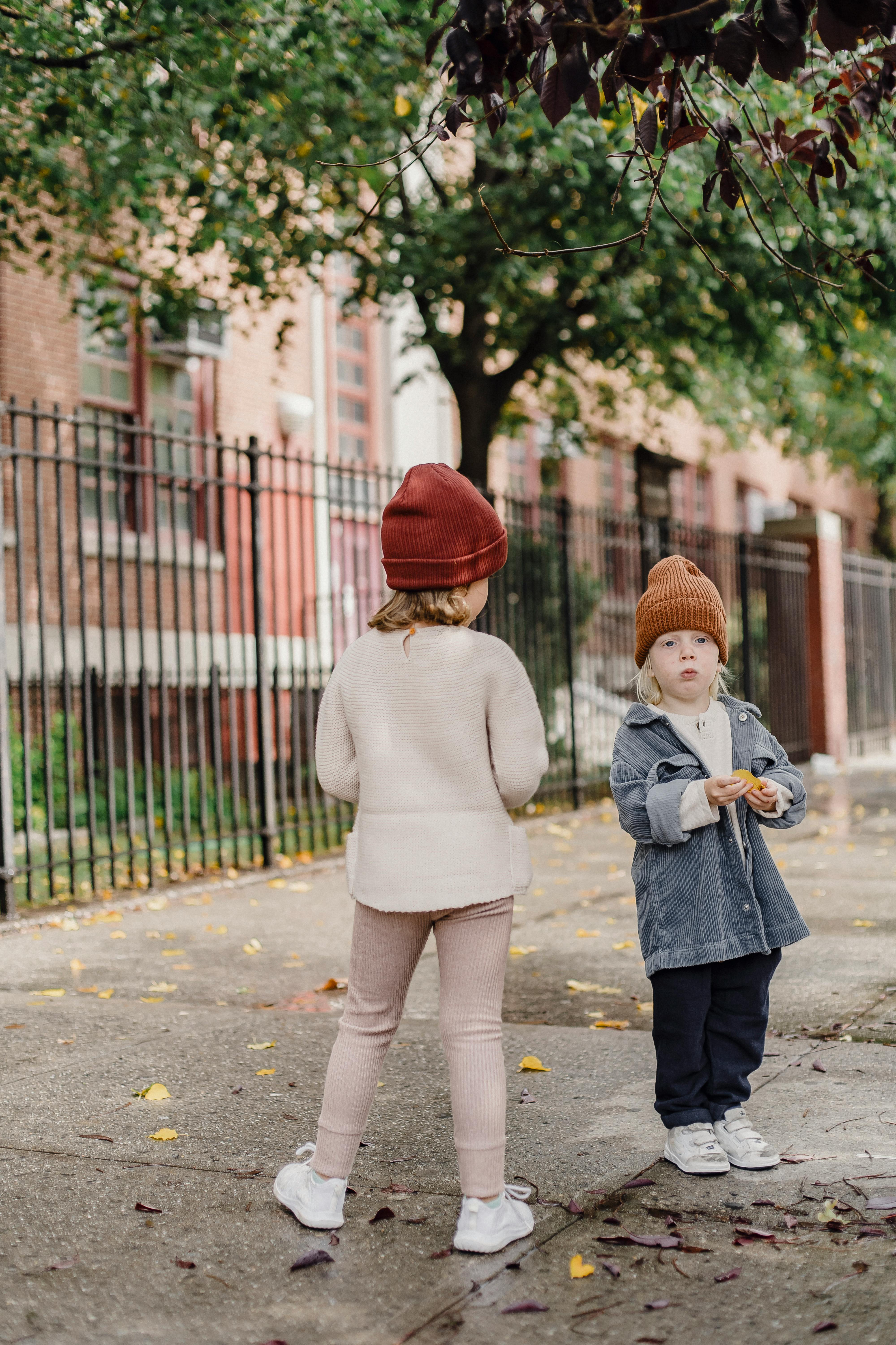 little siblings standing on footpath