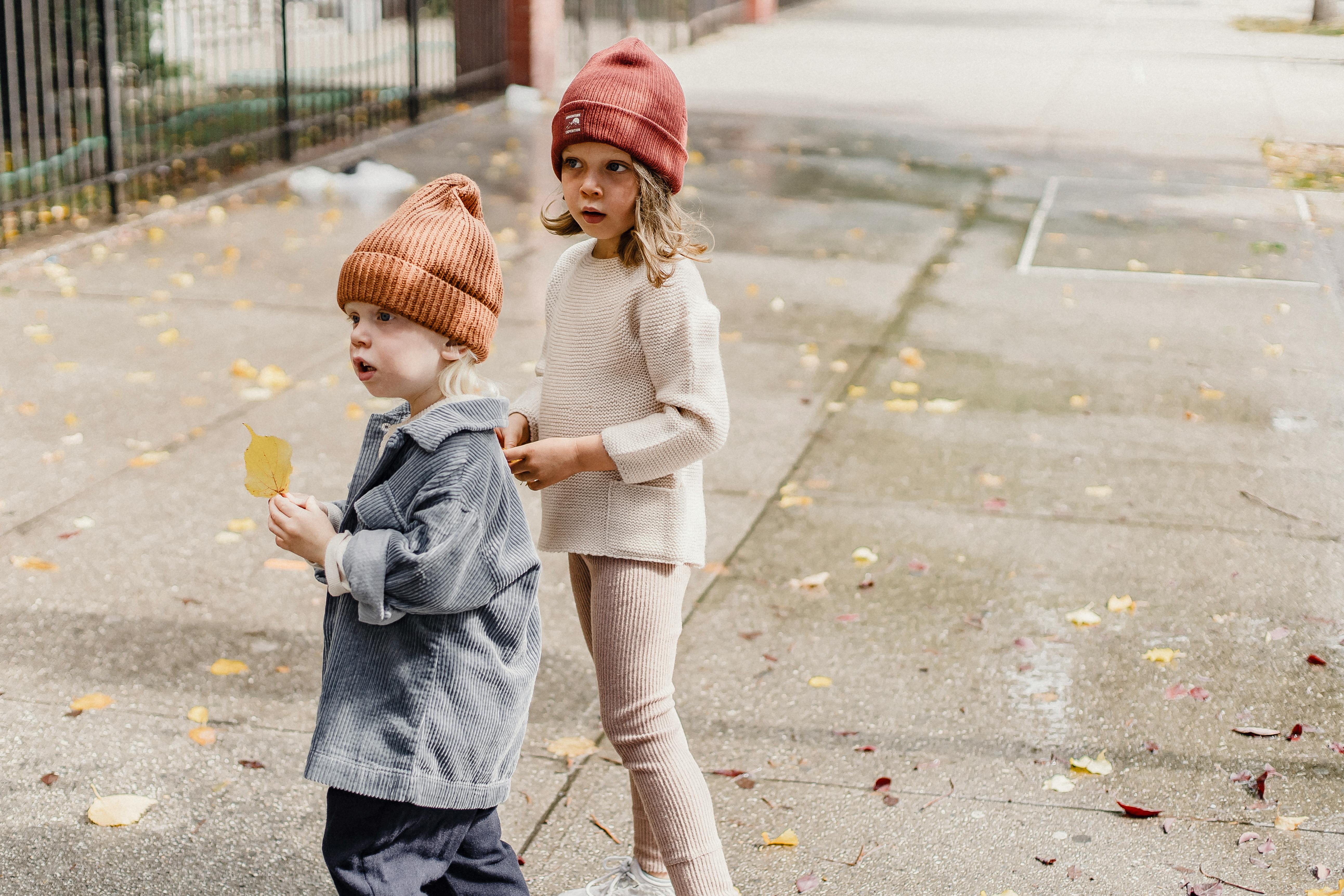 adorable children standing on autumn sidewalk