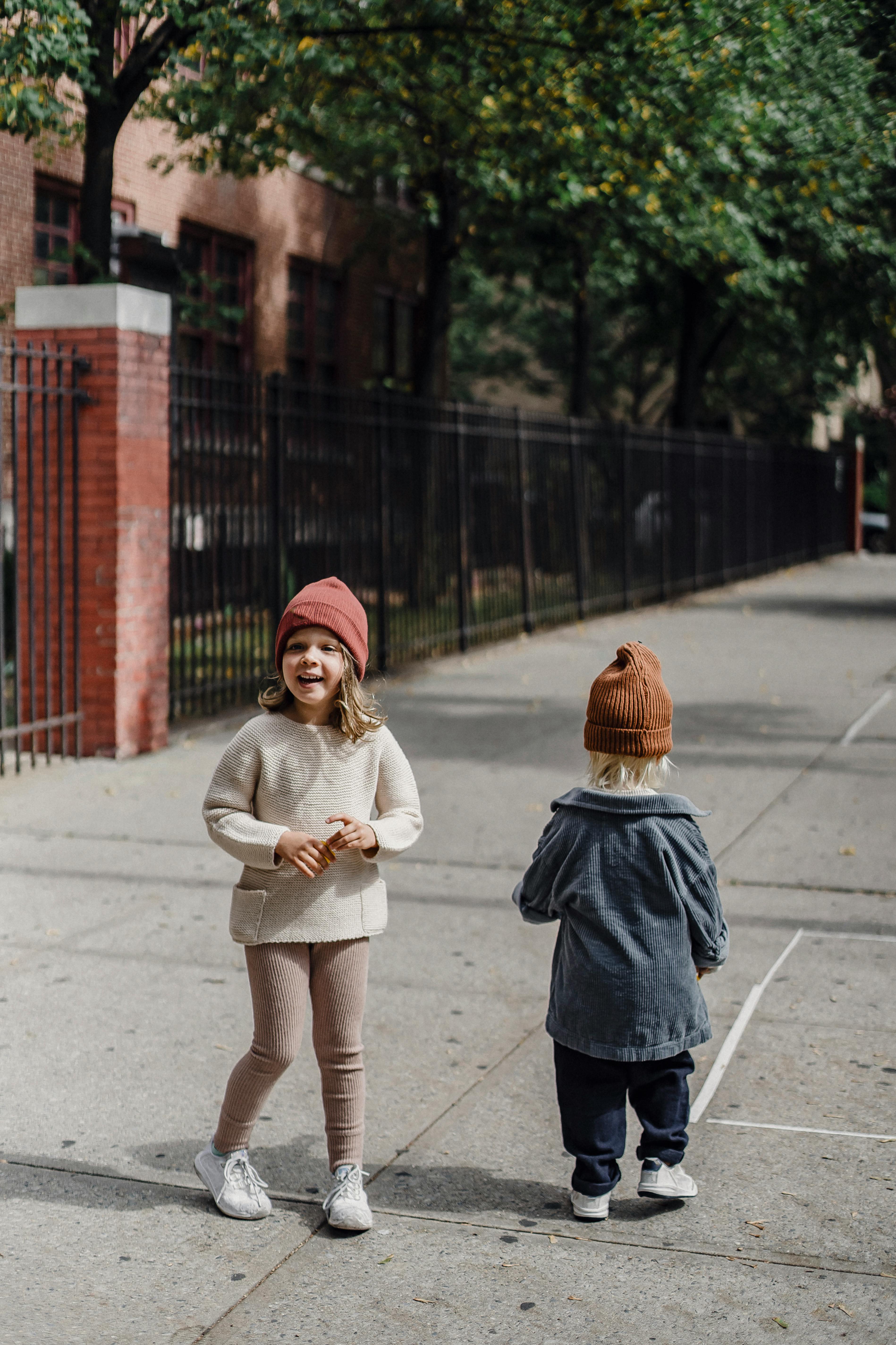 cute siblings walking on sidewalk