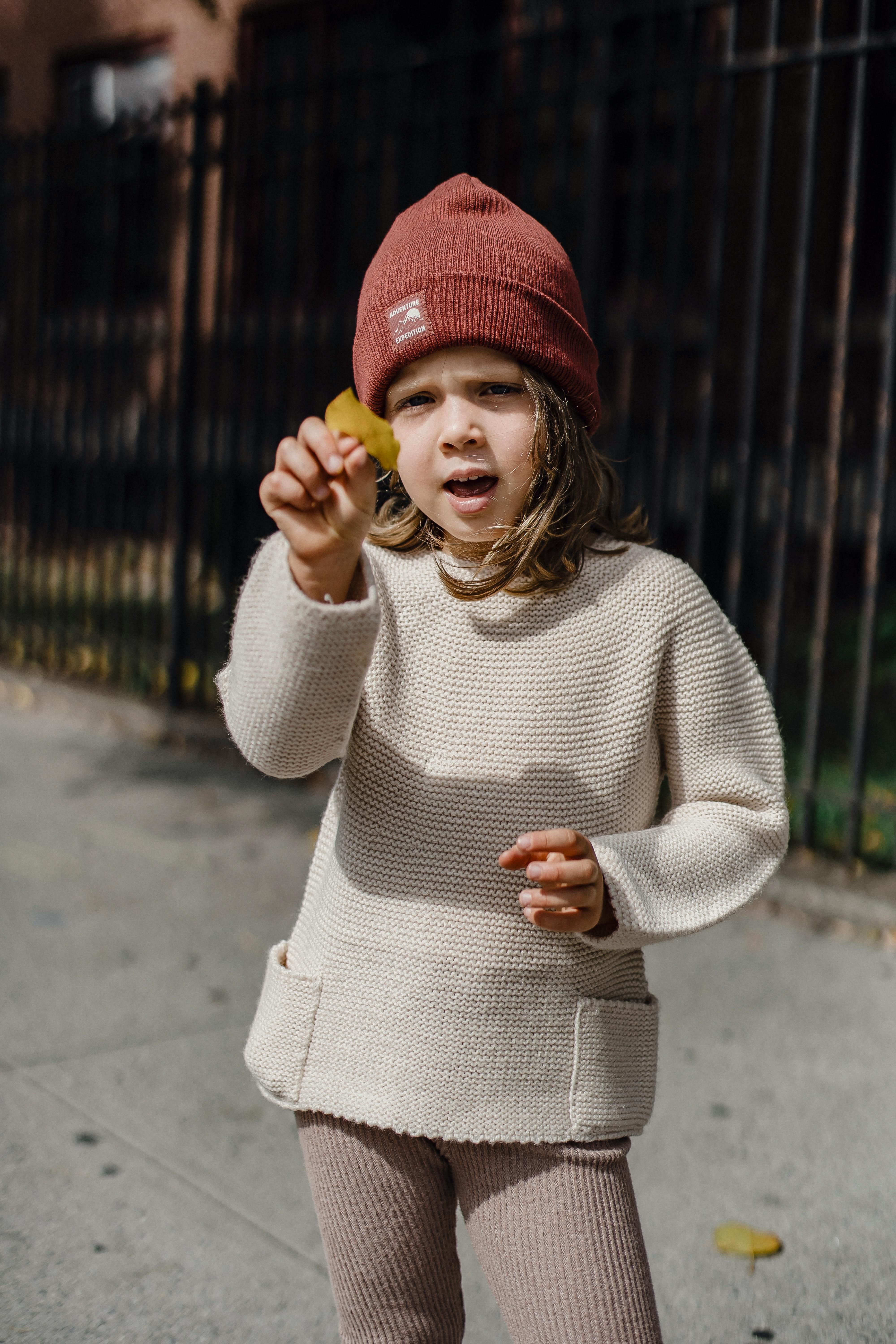 cute girl with dried leaf on pathway