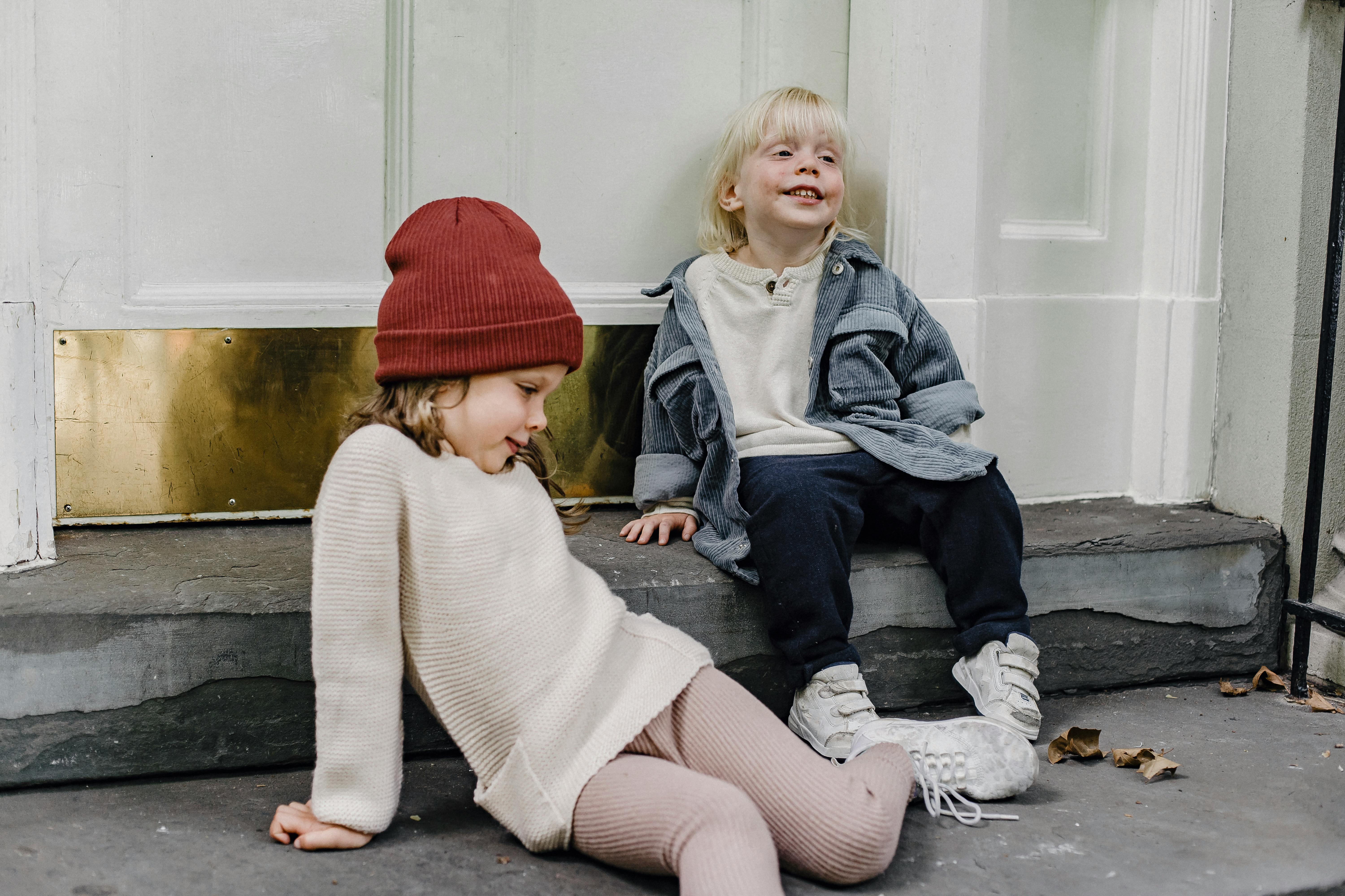 happy siblings sitting on doorstep