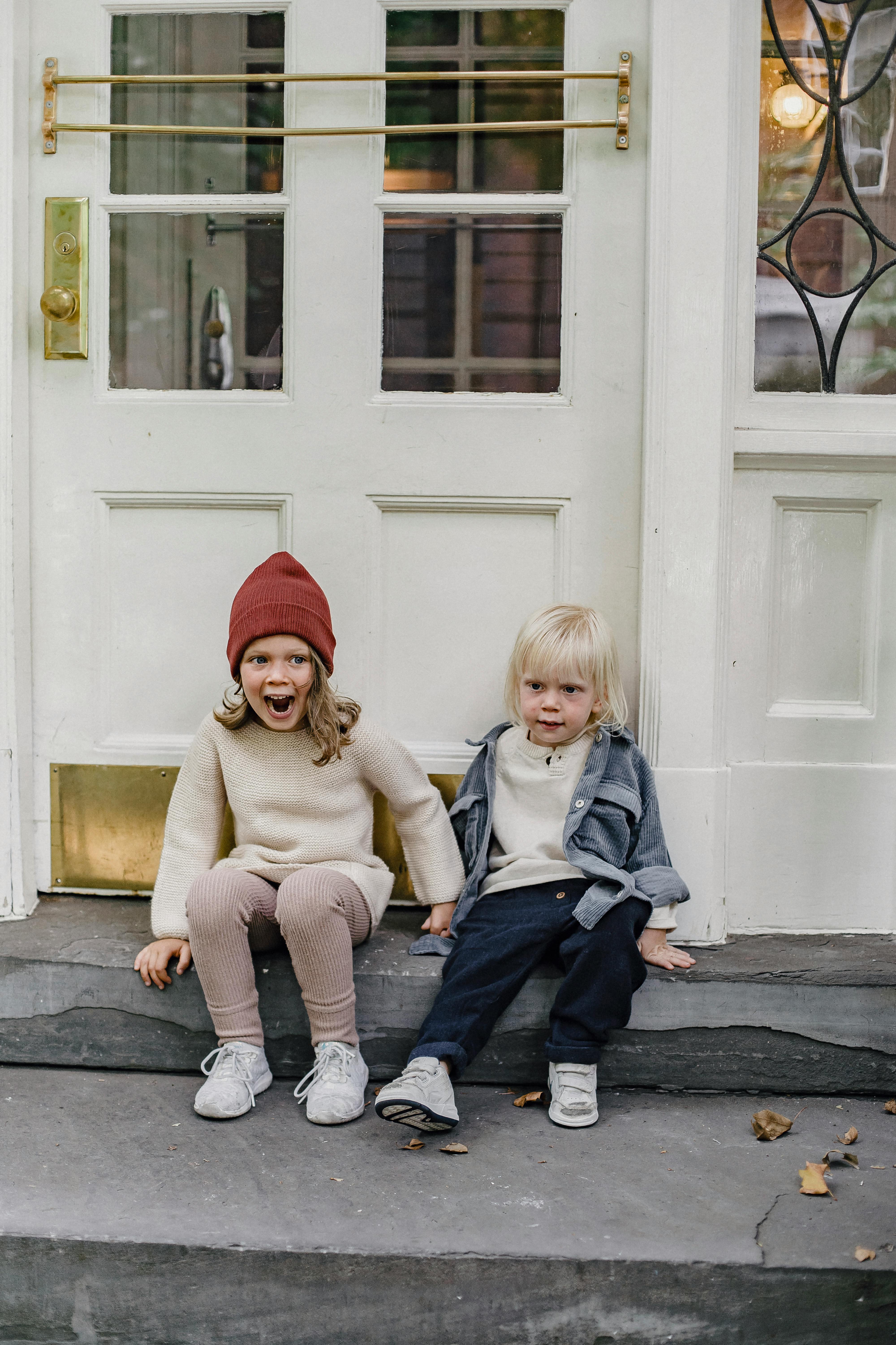 expressive siblings sitting on porch