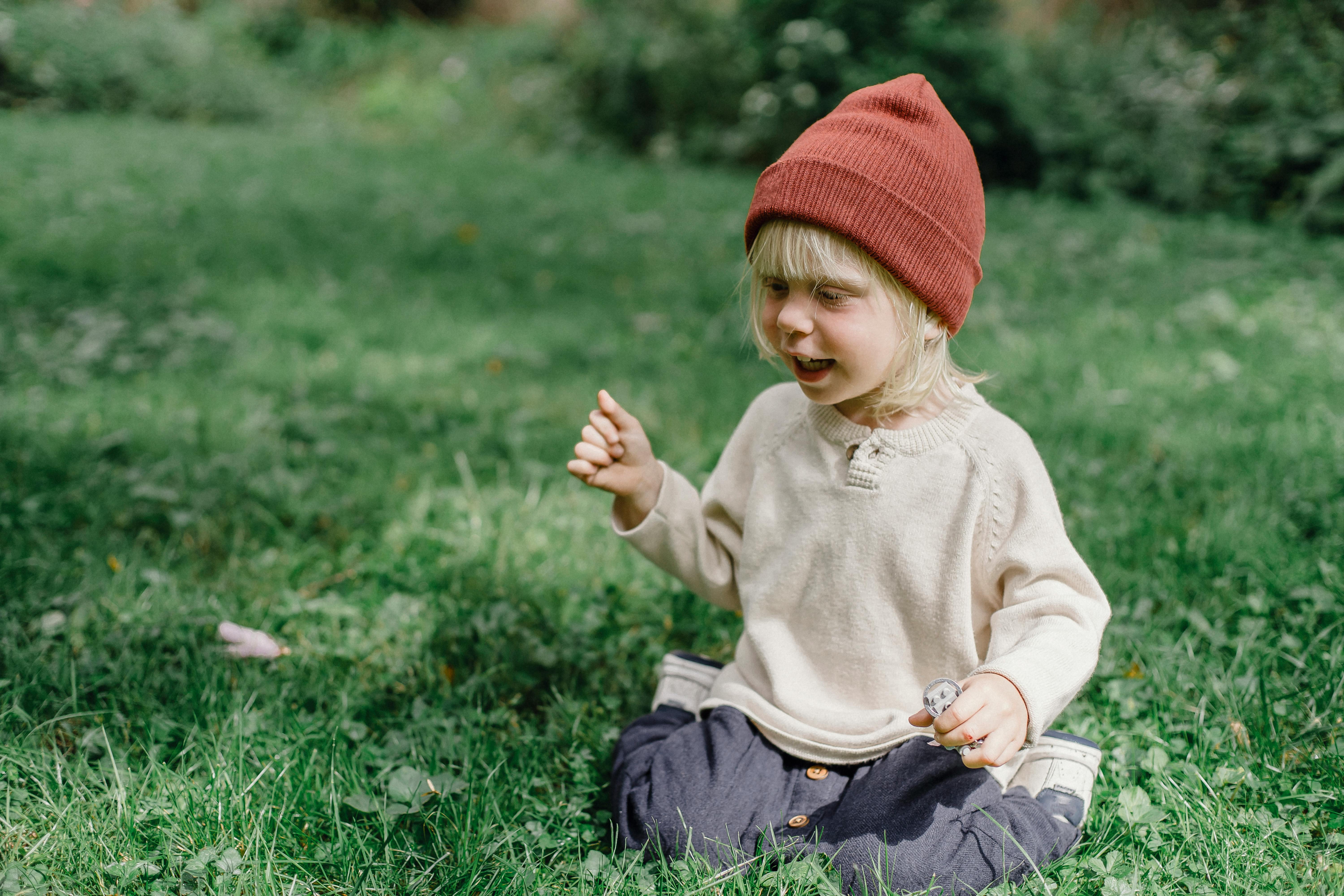 happy little boy sitting on grass