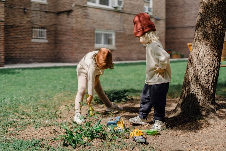 Little Kids Playing With Toys In Garden