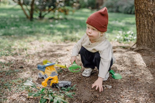 Cute little child playing with toys in yard