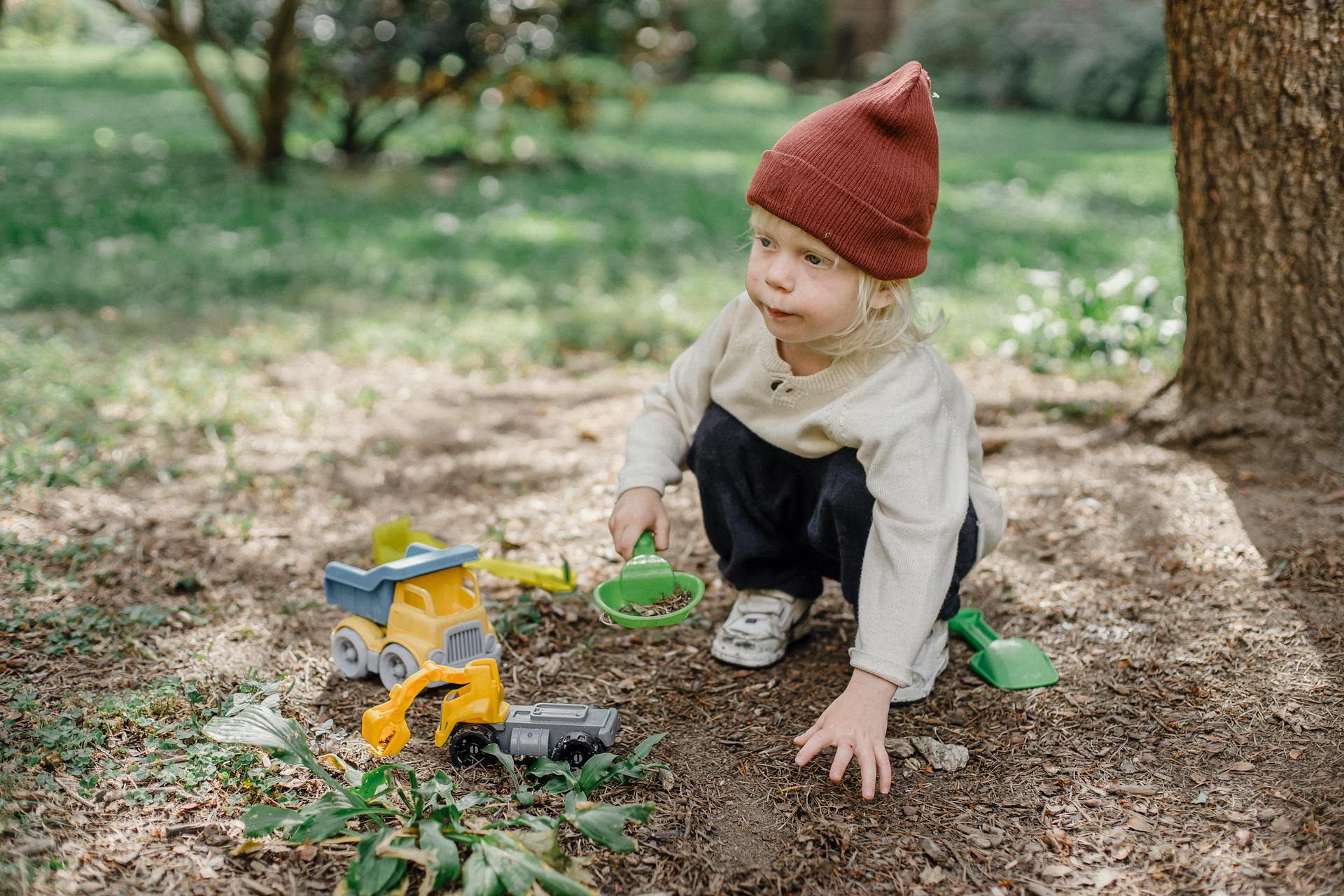 Cute little child playing with toys in yard