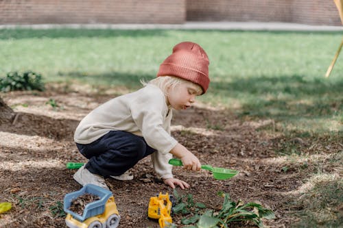 Menino De Suéter Marrom E Jeans Azul Brincando Com Blocos De Brinquedo De Plástico Amarelo E Vermelho