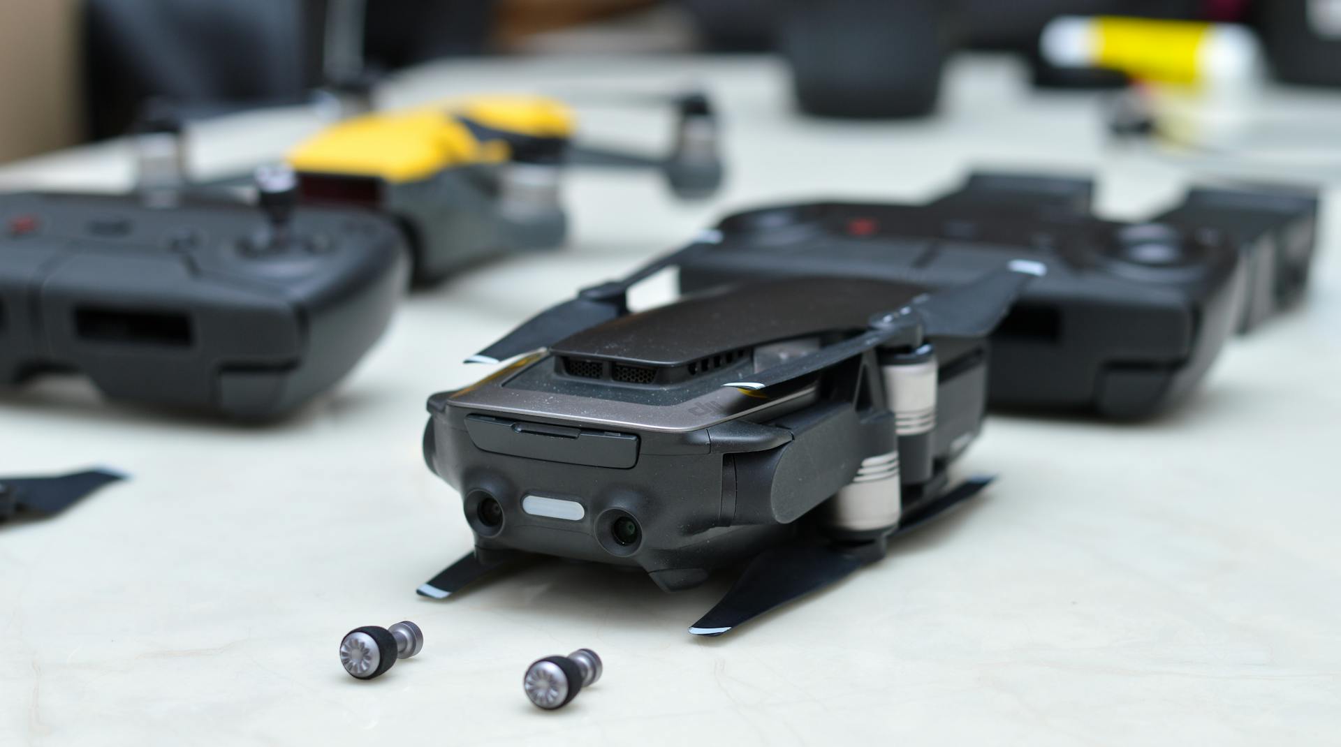 Close-up view featuring drones and controllers on a table, showcasing modern technology.