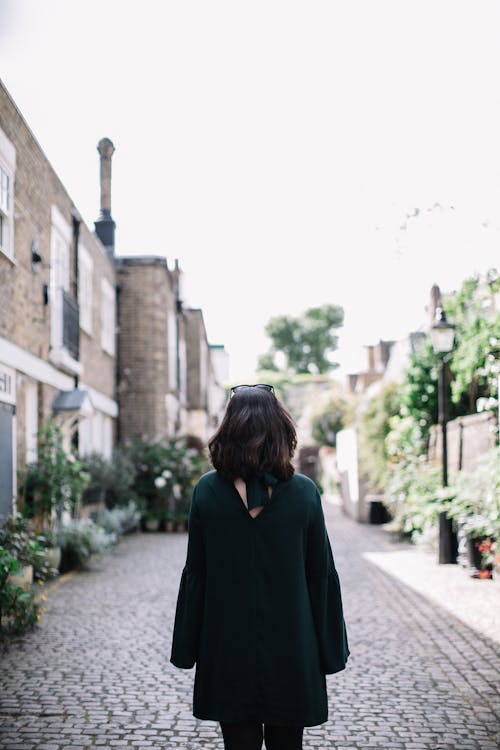 Photo of Woman Wearing Green Dress Standing in a Pathway · Free Stock Photo