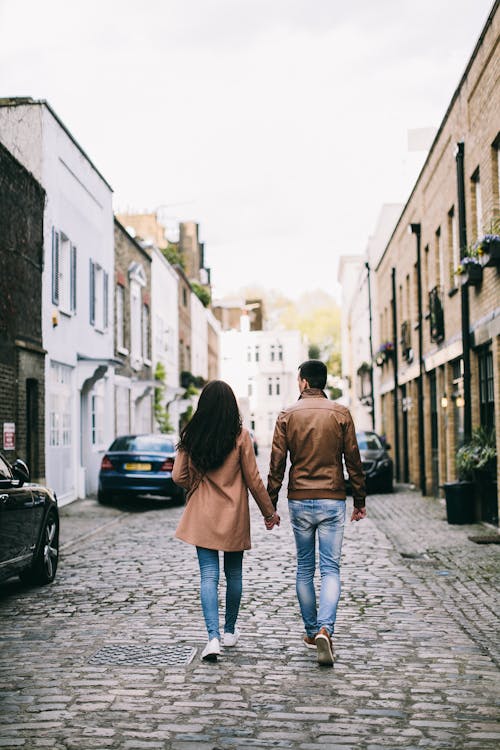 Femme En Veste Marron Et Jeans En Denim Bleu Marchant Sur Le Trottoir