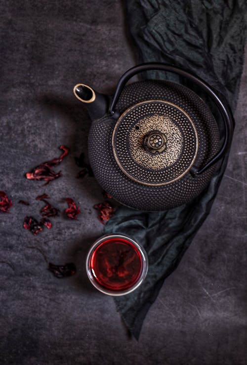 Black Teapot Beside the Glass Cup