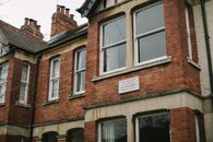 Brown Brick Building With White Wooden Framed Glass Window