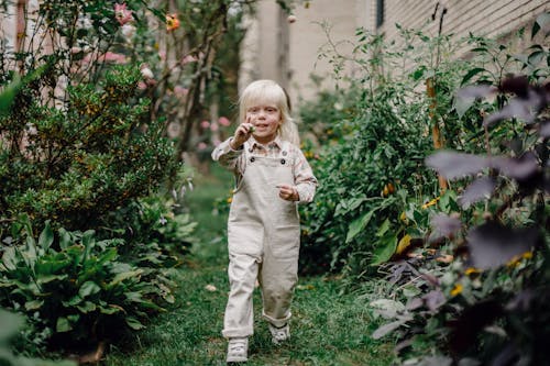 Cheerful child demonstrating picked berry in green garden