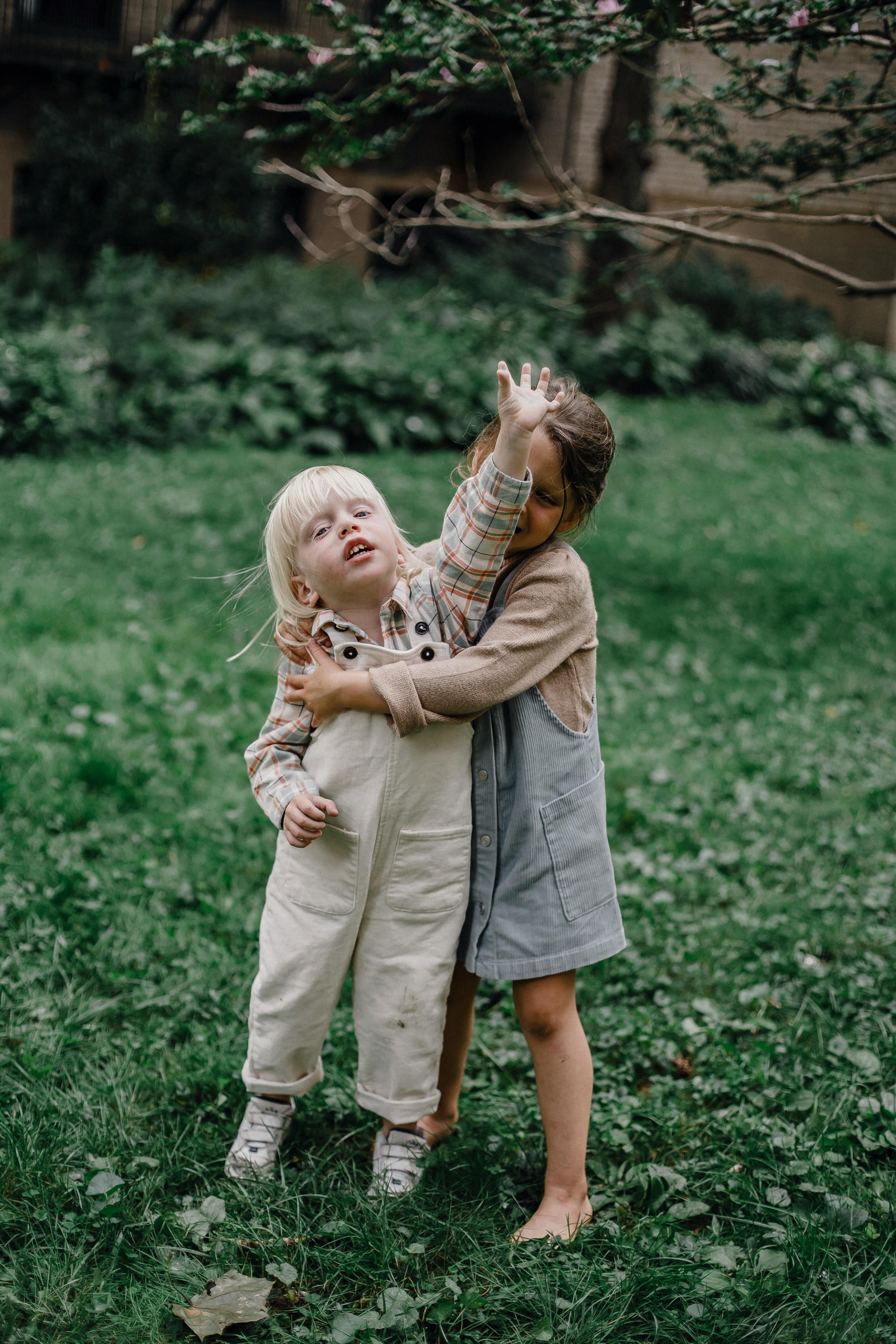 cute children playing on lawn with fresh green grass