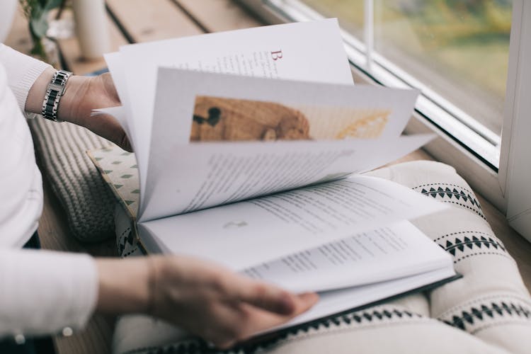 Hands With Open Book On Pillow