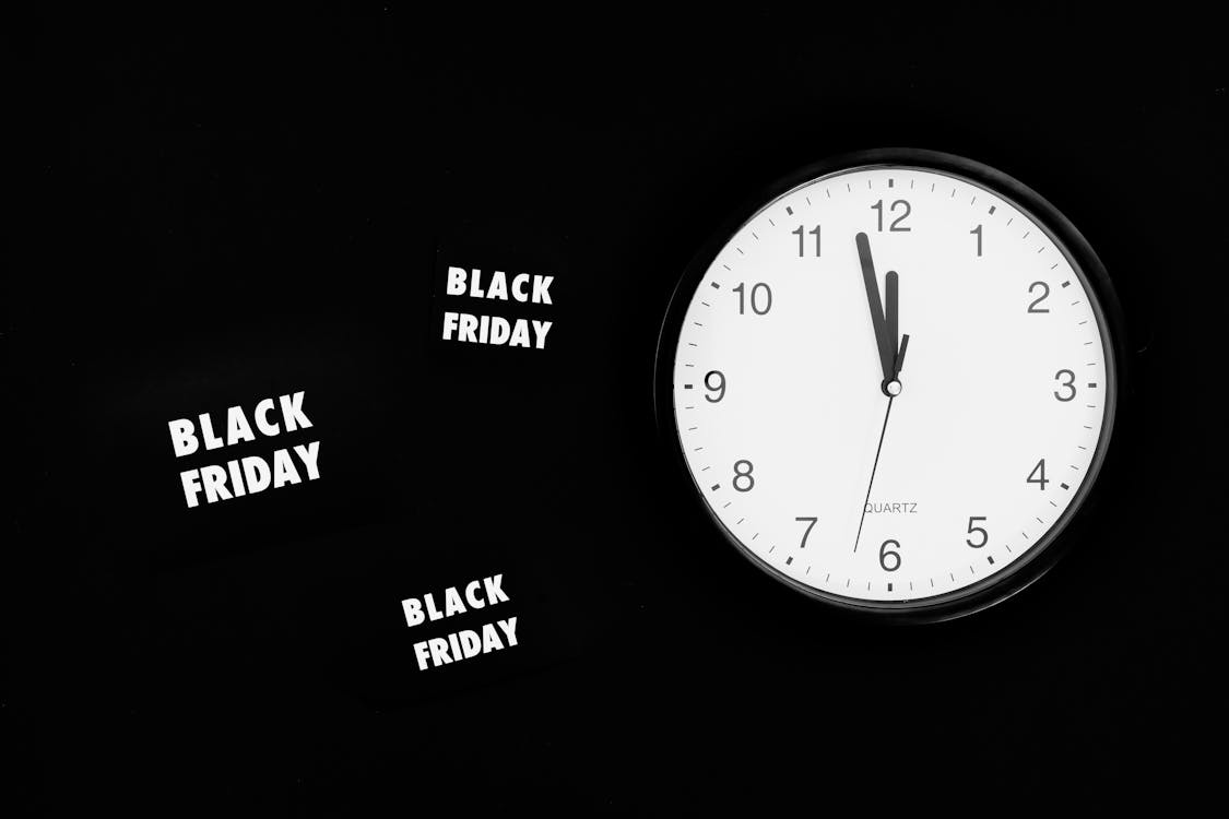 Free A Black Friday Sale Signage Beside a Black and White Round Analog Wall Clock Stock Photo