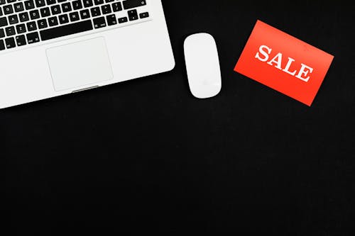 Free Macbook Pro Beside Red and White Sale Card Stock Photo