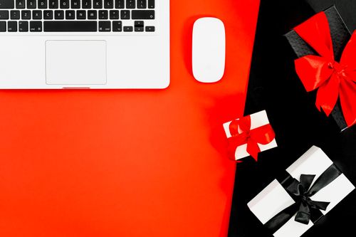 Free Flat lay of laptop with gift boxes on red background, perfect for holiday shopping themes. Stock Photo