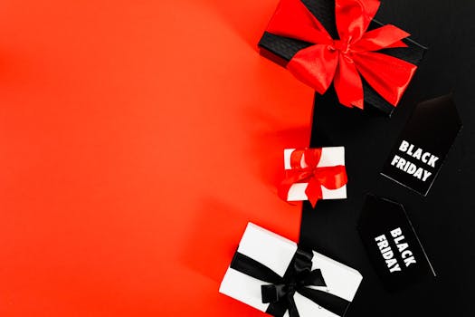 Stylish flat lay of Black Friday gift boxes with red ribbons on a vibrant red background.