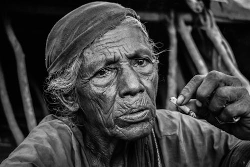 Free Monochrome Photo of an Elderly Woman Smoking a Cigarette Stock Photo