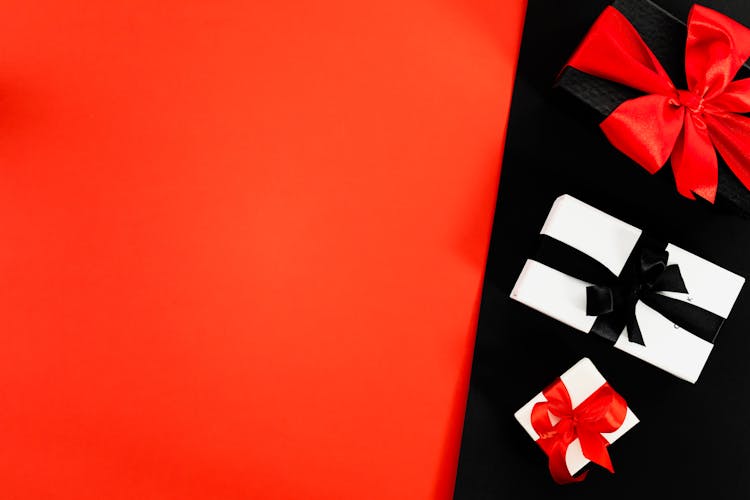  Three Boxes Tied With Ribbons On Red And Black Background