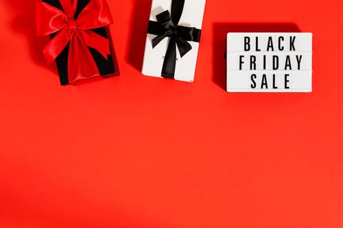 Free Festive Black Friday sale theme with gift boxes on a vibrant red background. Perfect for holiday promotions. Stock Photo