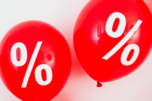 Free Two Red Balloons With Percentage Symbols on White Background Stock Photo