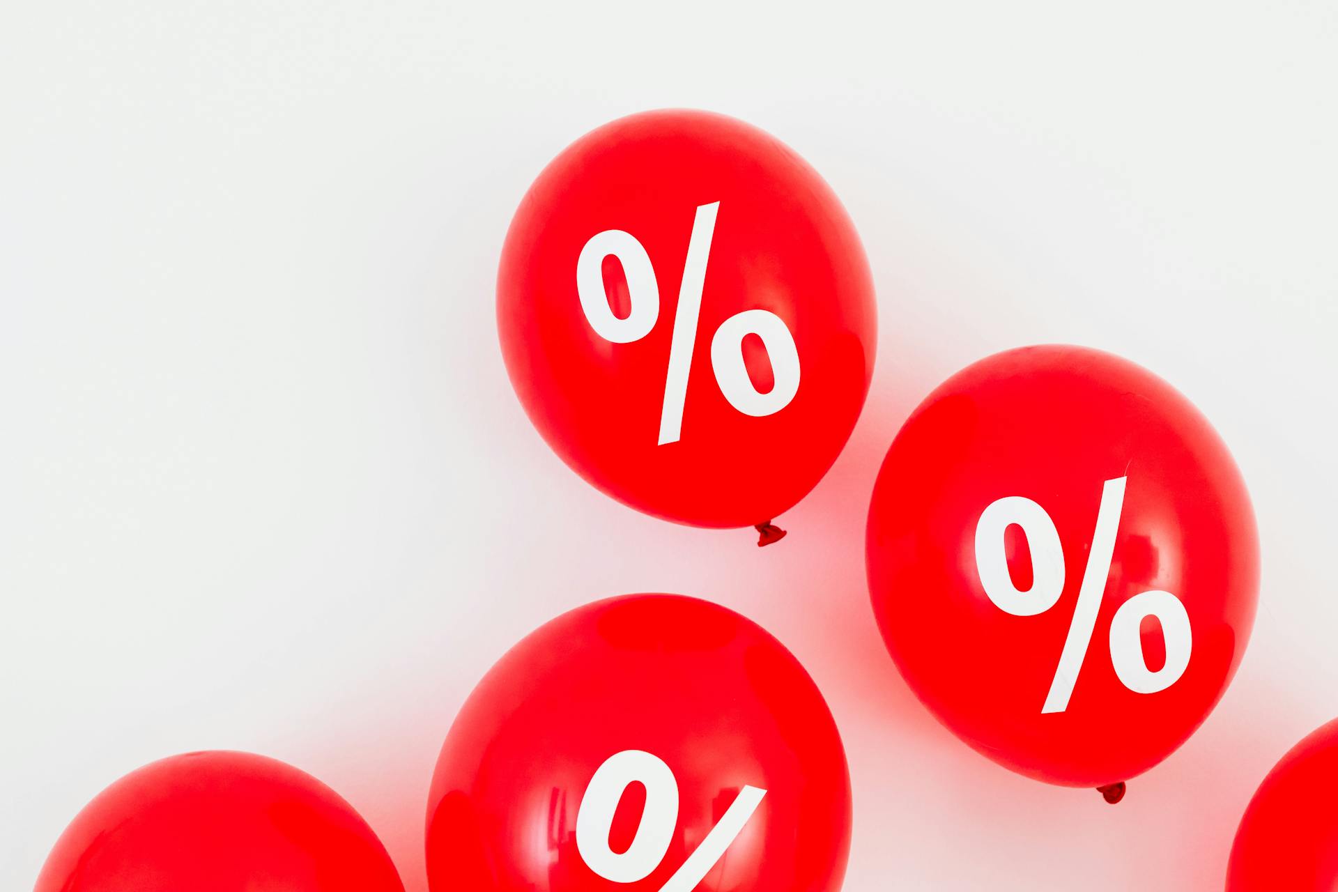 Bright red balloons with percent symbols, ideal for sales promotions and discounts.