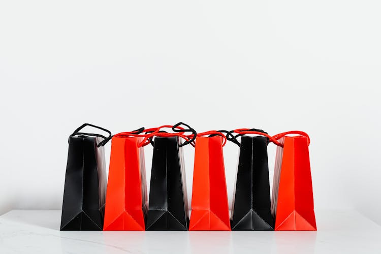 Black And Red Paper Bags On White Background