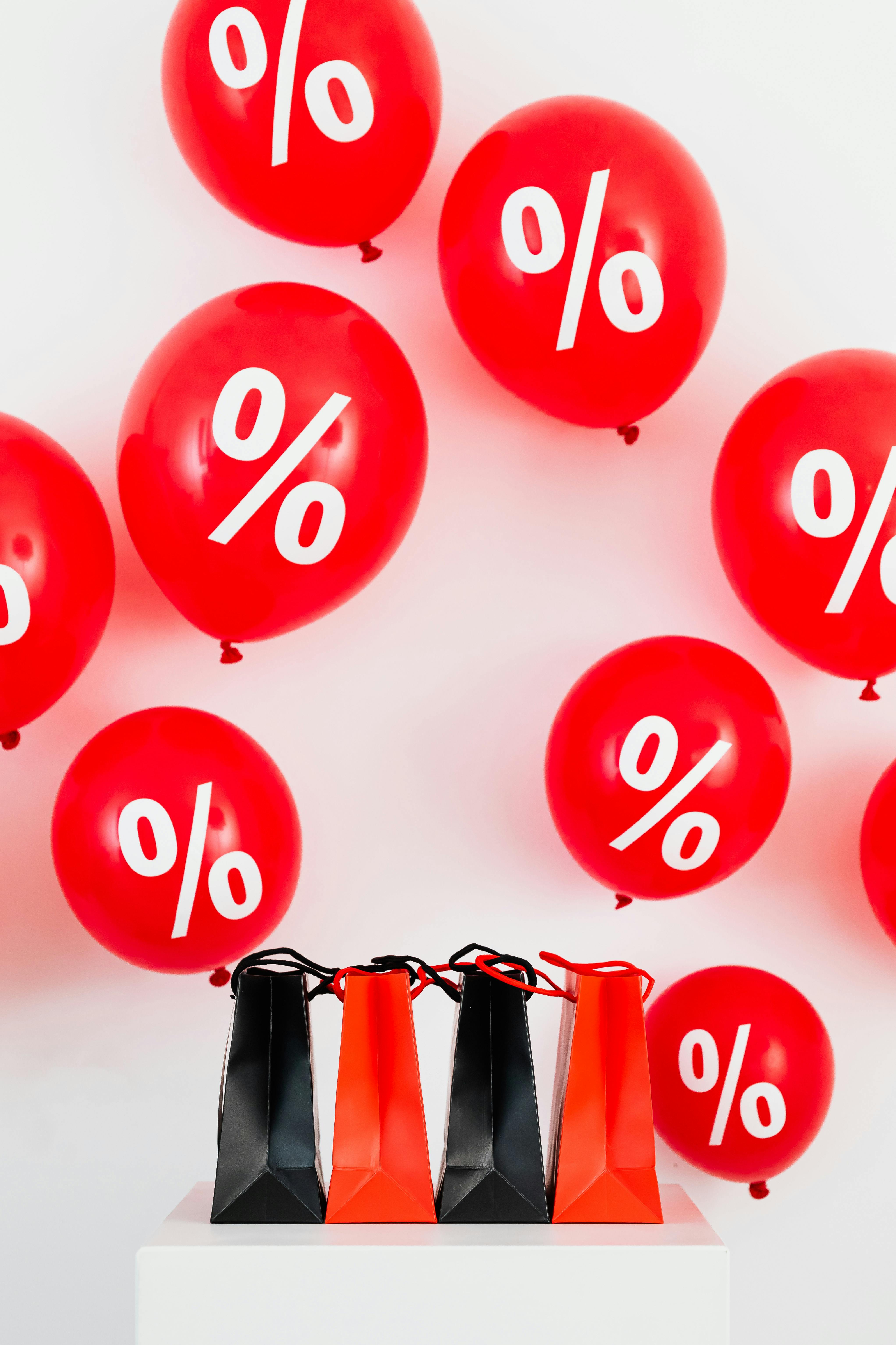 black and red paper bags against red balloons on white background