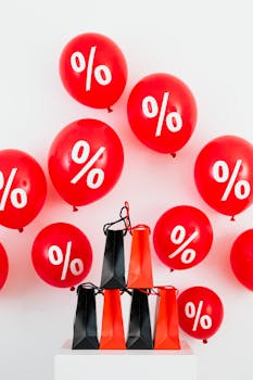 Vibrant red balloons with percentage signs and shopping bags for sales event.