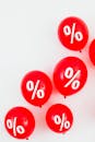 Red Balloons With Percentage Symbols on White Background