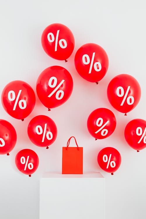 Free A Red Paper Bag in the Middle of Red Balloons With Percentage Symbols Stock Photo