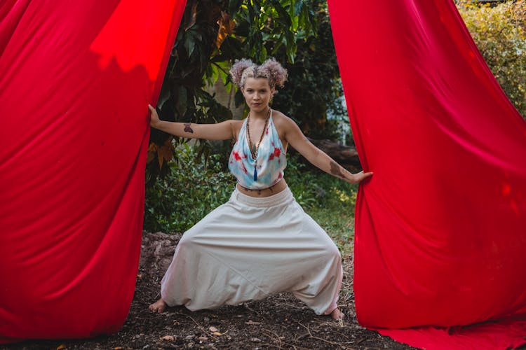 Positive Young Tattooed Lady With Silks While Practicing Aerial Yoga