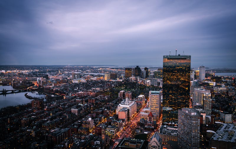 Stunning aerial view of Boston skyline at dusk, showcasing urban architecture and city lights.