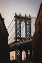 Old Brooklyn Bridge under white sky at sunset