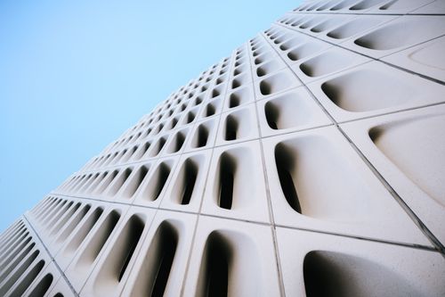 Free Low angle view of a modern architectural facade in Los Angeles against a clear blue sky. Stock Photo