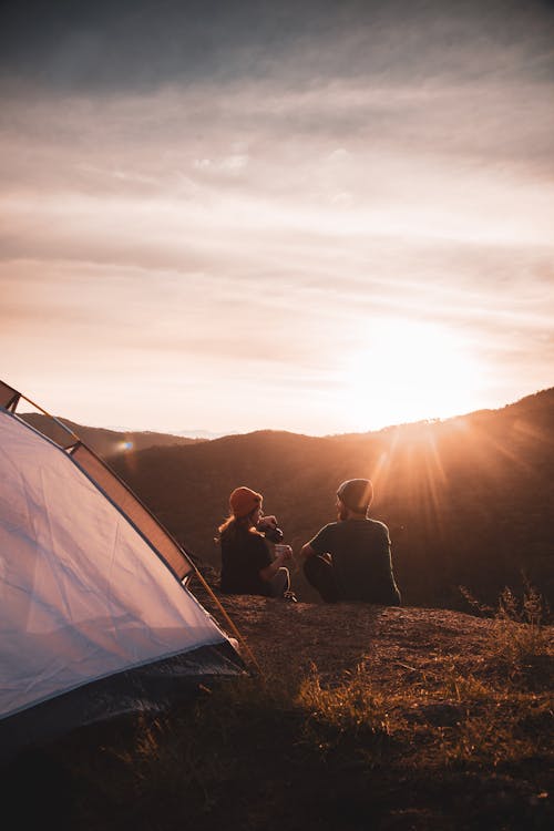 Free People Sitting on the Ground Near a Tent  Stock Photo