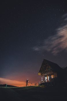 巴西星空下，一个孤身的身影站在小屋旁边
