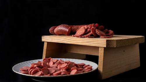 Free Delicious cut sausages on cutting board and plate Stock Photo