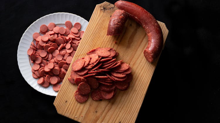 Sliced Sausage On Cutting Board And Plate